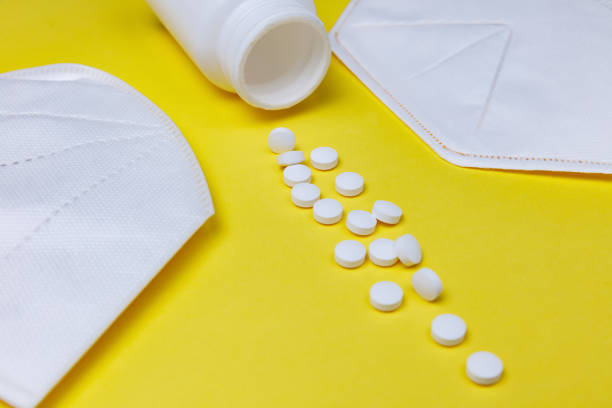 istock pills and protective masks on a yellow background 1217011912