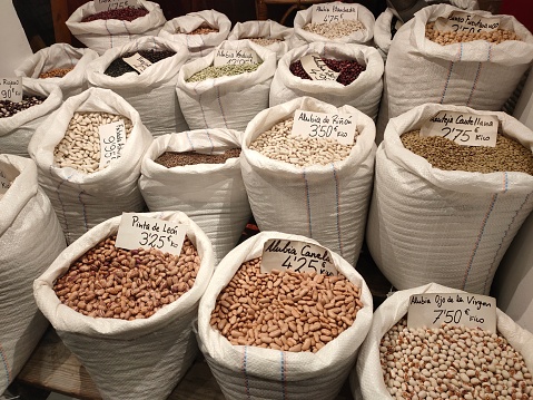 Assorted dried soybeans soy beans legumes in burlap sack bag as: white soybean, mung bean and adzuki bean isolated on white background leaving copy space