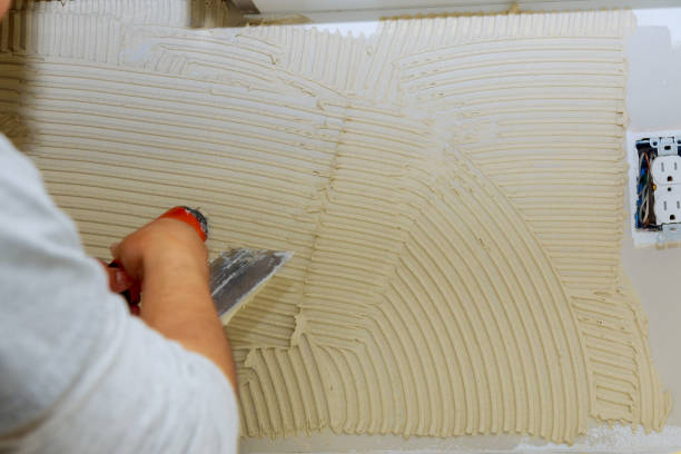 istock Handyman applying ceramic tiles on bathroom walls 1217013151