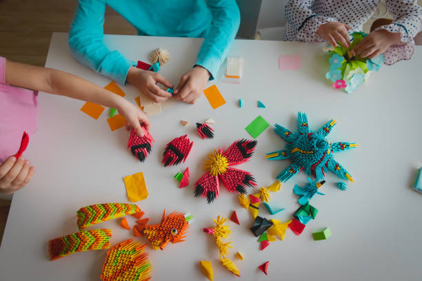 istock kids making origami crafts with paper, learning activities 1217015637