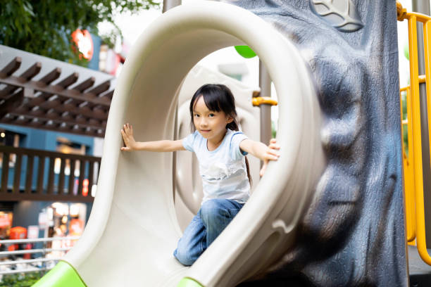 Portrait of a happy and playful Taiwanese ethnicity preschool age girl playing in a public park.