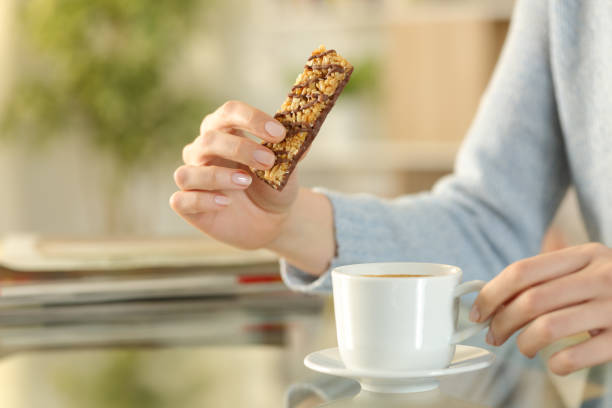 istock Woman hands holding a snack bar with coffee cup 1217019919