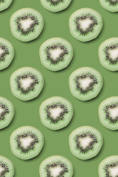 istock Kiwi slices pattern on a green background. Food texture. Kiwi seamless texture. 1217019963