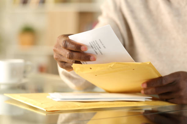 自宅でパッド入りの封筒を開ける黒人男性の手 - opening mail letter envelope ストックフォトと画像