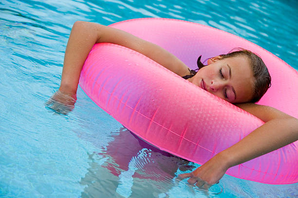 menina em rosa tubo de piscina flutuante - swimming tube inflatable circle imagens e fotografias de stock