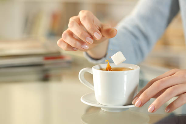 istock Woman hand throwing sugar cube on a coffee cup 1217022293