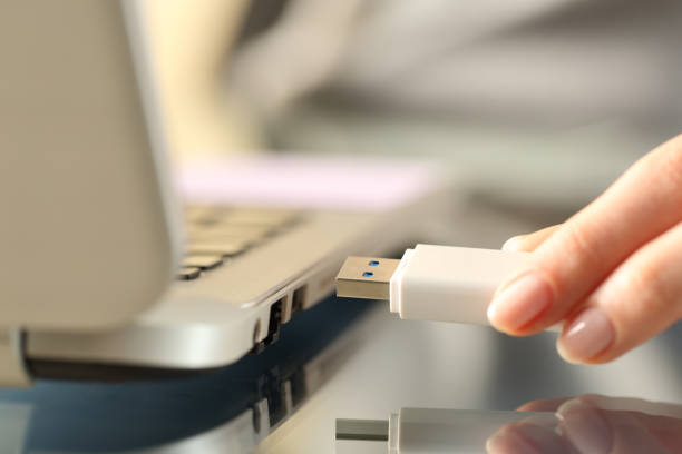 femme connectant la commande flash d’usb sur un ordinateur portatif - usb photos et images de collection