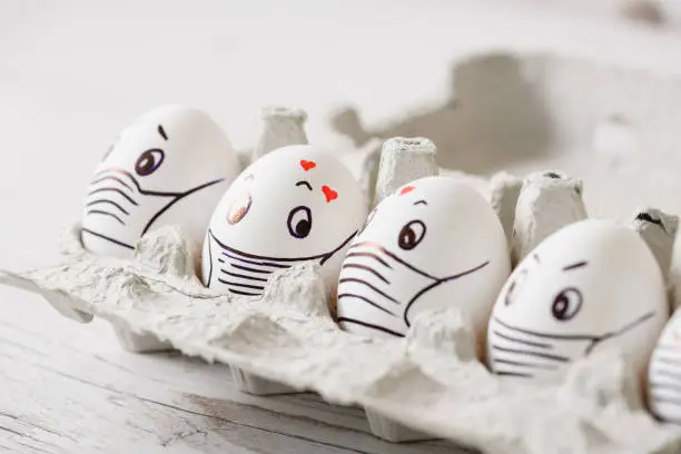 Faces in masks drawn on Easter eggs