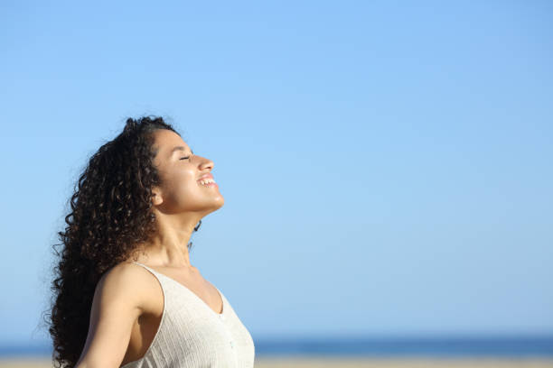 giovane donna rilassata che si arrassa e si gode il sole sulla spiaggia - sollievo foto e immagini stock