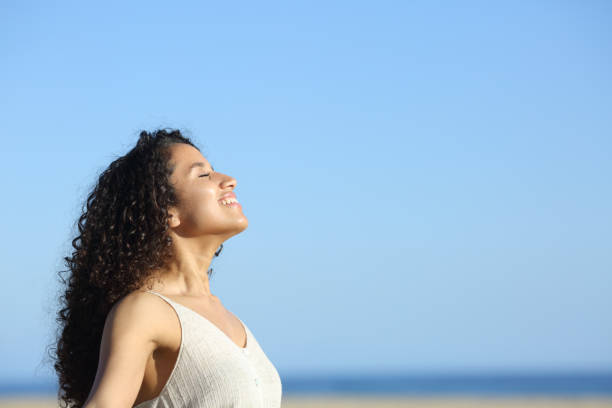 istock Relaxed young woman breating and enjoying sun on the beach 1217023191