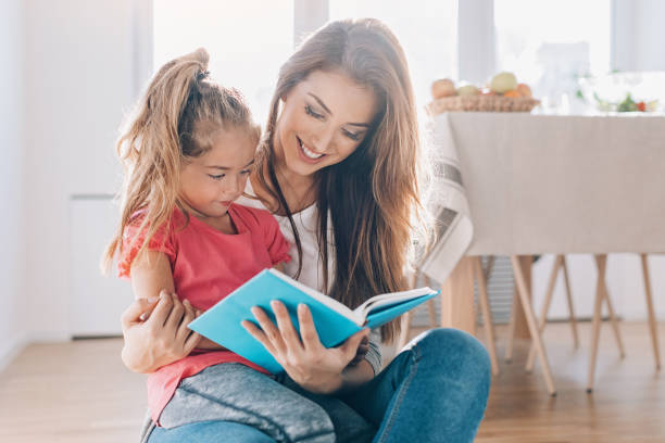 istock Mother and daughter reading a book together 1217023228