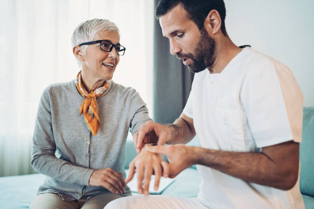 Doctor examining senior woman's arm and wrist Doctor with a senior patient osteoarthritis photos stock pictures, royalty-free photos & images