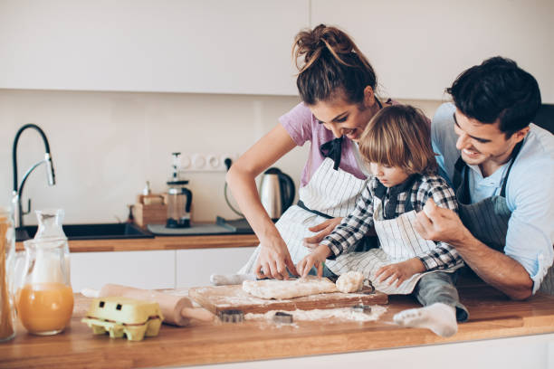istock Young family with small child making cookies 1217023274