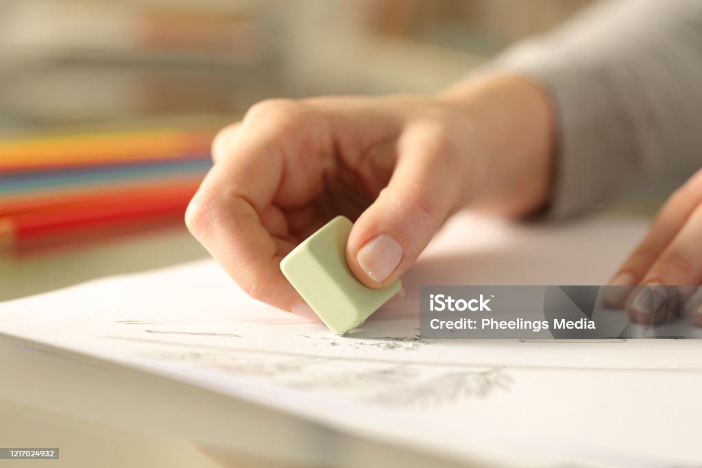 Frau mit Gummi-Löschzeichnung auf einem Schreibtisch - Lizenzfrei Radiergummi Stock-Foto