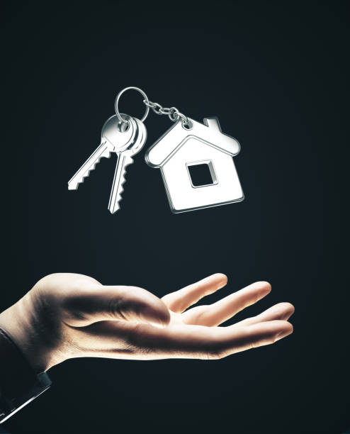 istock Hand holding key to house on black 1217025445