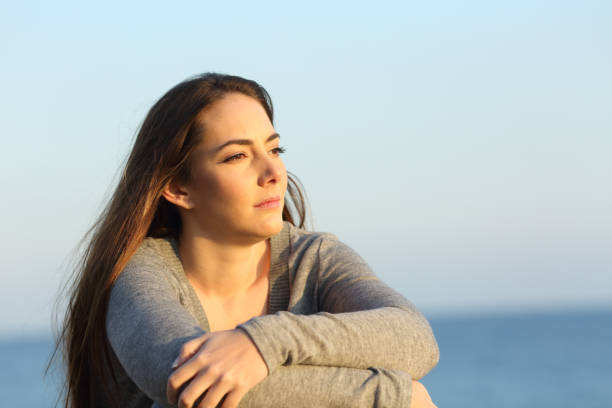 istock Serious woman thinking looking at horizon on the beach 1217026675