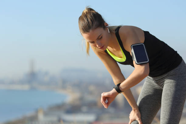 corredor cansado verificando smartwatch após exercício - pulse clock - fotografias e filmes do acervo