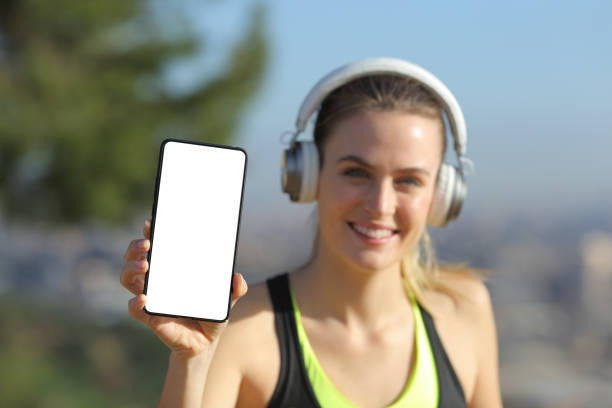 istock Runner with headphones showing phone screen 1217028290