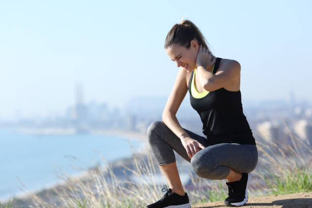 Runner suffering neck ache after sport Injured runner woman suffering neck ache after sport in city outskirts muscle and joint aches stock pictures, royalty-free photos & images