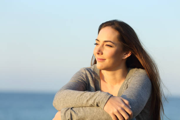 istock Confident woman watching sunset on the beach 1217029346