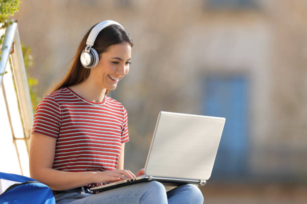 istock Happy student e learning with headphones and laptop in a campus 1217030728
