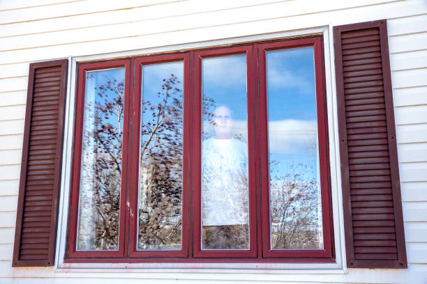 istock Man in isolation looking out of a window 1217031449