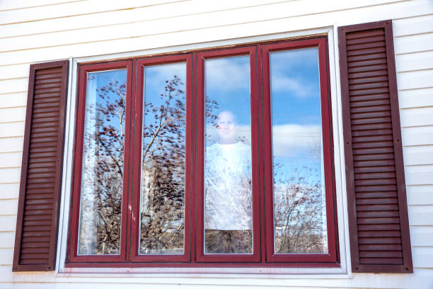 istock Man in isolation looking out of a window 1217031451