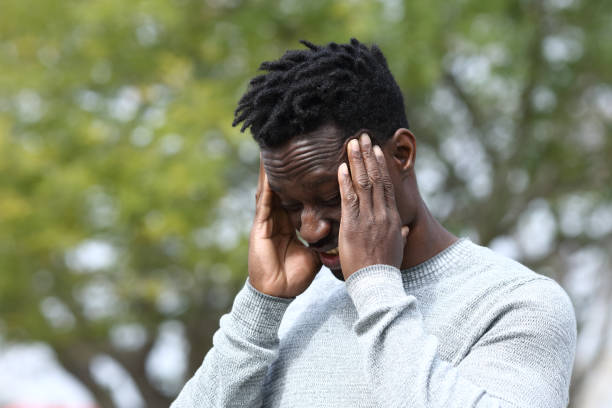 istock Black man suffering from migraine rubbing temples 1217031618