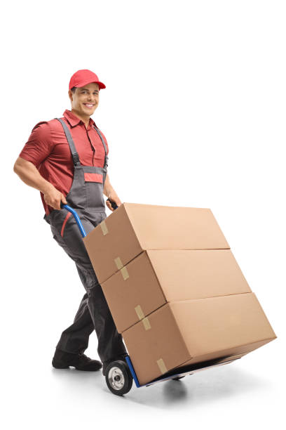 istock Male worker pushing a hand truck loaded with boxes 1217031665