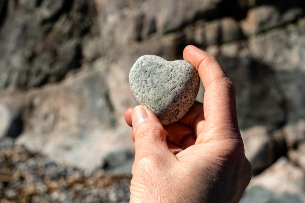 istock Heart shaped rock held in a persons hand 1217033137