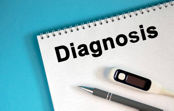 istock DIAGNOSIS - text on a notepad. Lie a pen and a medical thermometer 1217035360
