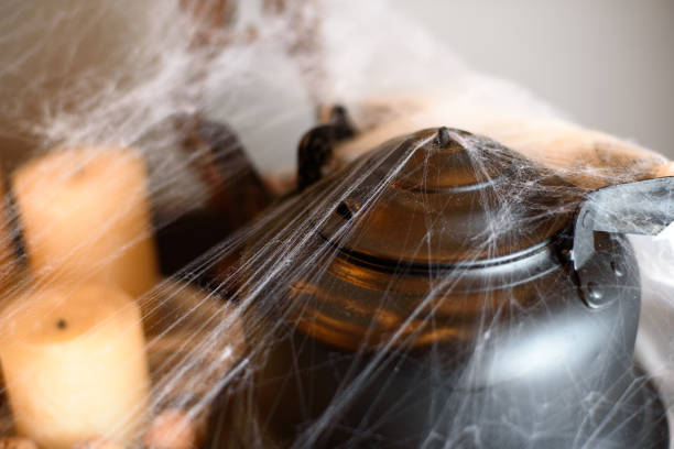 istock Black teapot with nuts and candles in spider halloween 1217036432