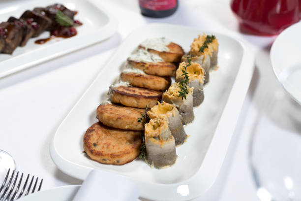 istock Seafood. Fish cakes and cheese rolls stuffed with fish fillet on a plate on a white background 1217037535