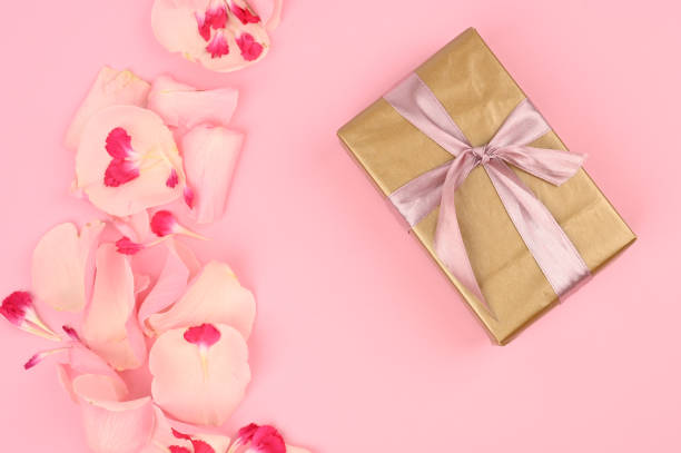 istock Flat lay composition with beautiful flowers and a gift box on a pink background. Space for text 1217039785