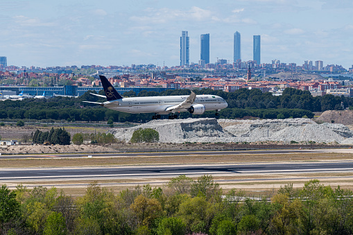 MADRID, SPAIN - APRIL 14, 2019: Saudi Arabian Airlines Boeing 787 passenger plane landing at Madrid-Barajas International Airport Adolfo Suarez In the background we can see the city of Madrid, with the towers of the financial district.