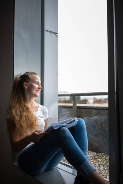 istock female university/highschool student with books in library 1217041399