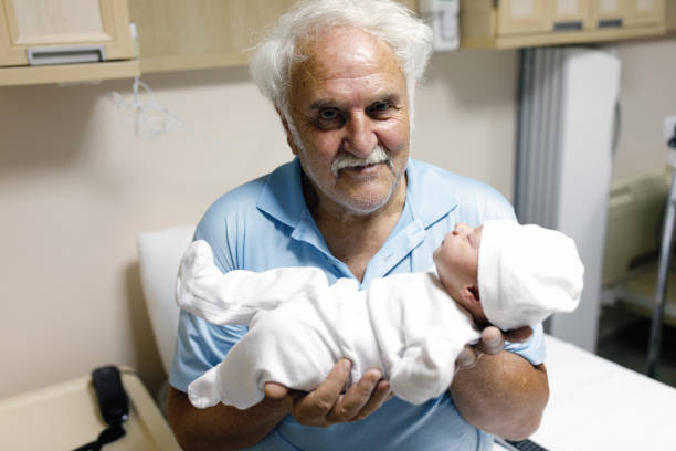 abuelo sosteniendo a su nieto recién nacido en el hospital - ahijado fotografías e imágenes de stock