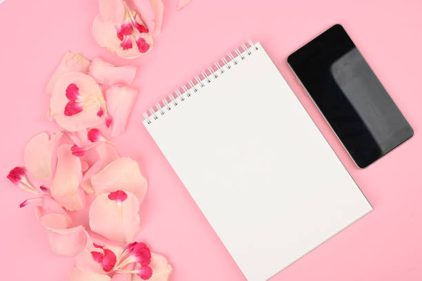 istock Female desktop with roses, notebook and smartphone. Spring minimal concept. Space for text 1217041793