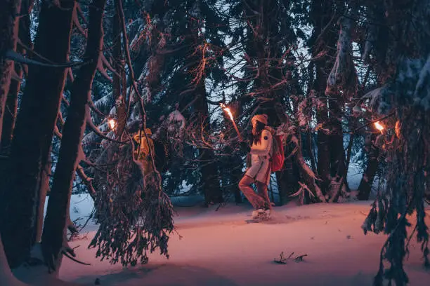 Photo of Friends hike through snow at dusk