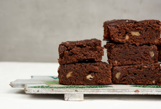 istock stack of square baked pieces of brownie chocolate cake with walnuts 1217049478