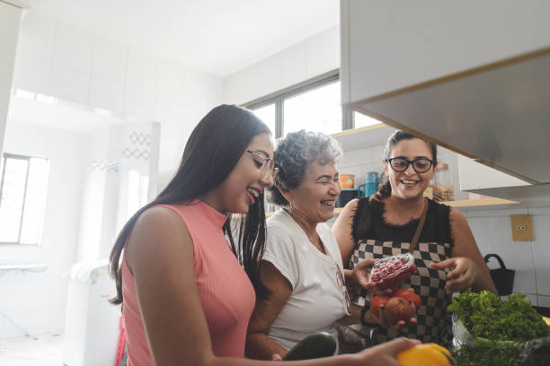 abuela, madre e hija desempaquetando comestibles en la cocina - estilo de vida saludable fotos fotografías e imágenes de stock