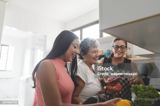 Abuela Madre E Hija Desempaquetando Comestibles En La Cocina Foto de stock y más banco de imágenes de Familia