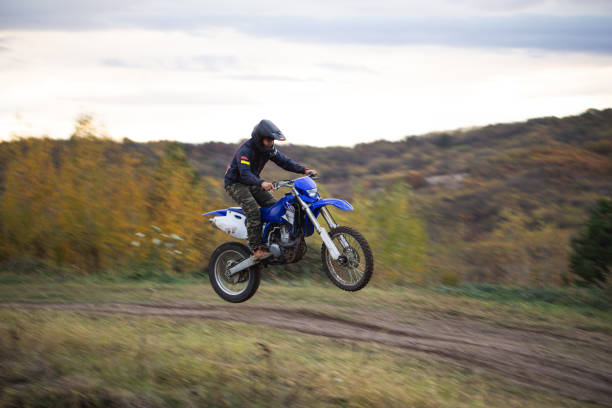 istock Motocross athlete jumping with a motorcycle on a dirt road 1217050980