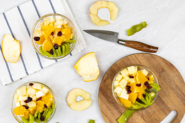 istock Fruit salad flat lay kiwi orange apple top view grey marble table 1217051571
