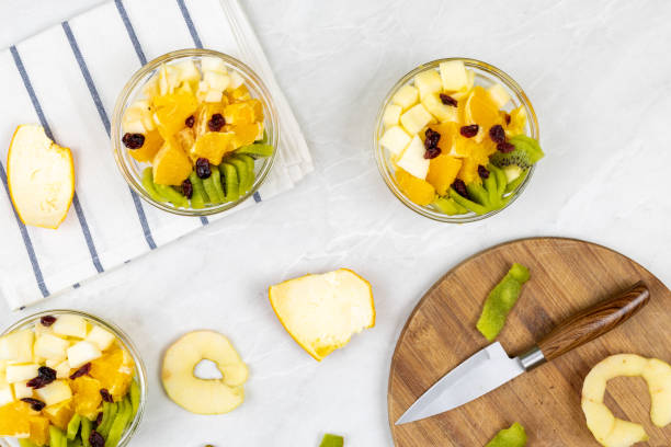 istock Fruit salad flat lay kiwi orange apple top view grey marble table 1217051762