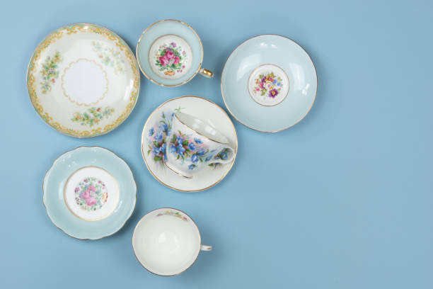 Pretty china teacups and saucers on blue background