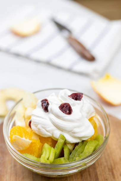 Fruit salad whipped cream flat lay white marble table