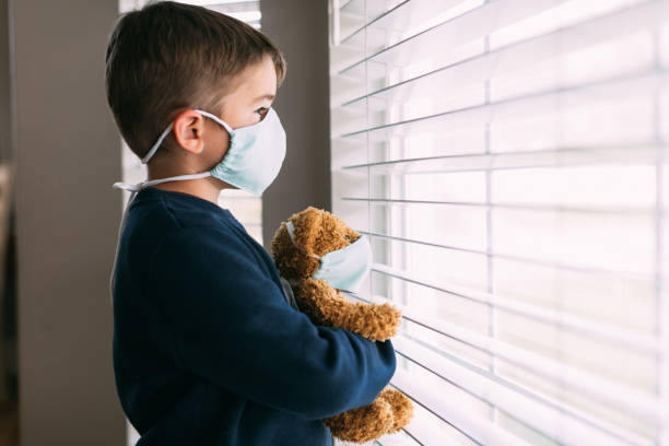 istock Young Boy and his Teddy Wearing Face Masks 1217055628