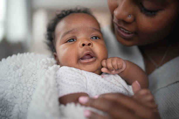 istock Happy mother snuggling baby 1217055988