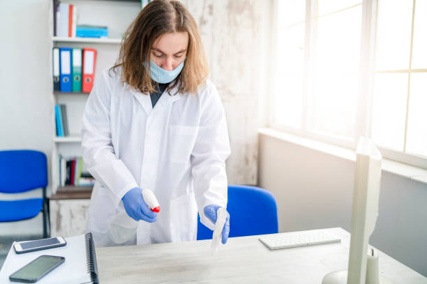 istock One man in protective gloves disinfecting office work space 1217057266